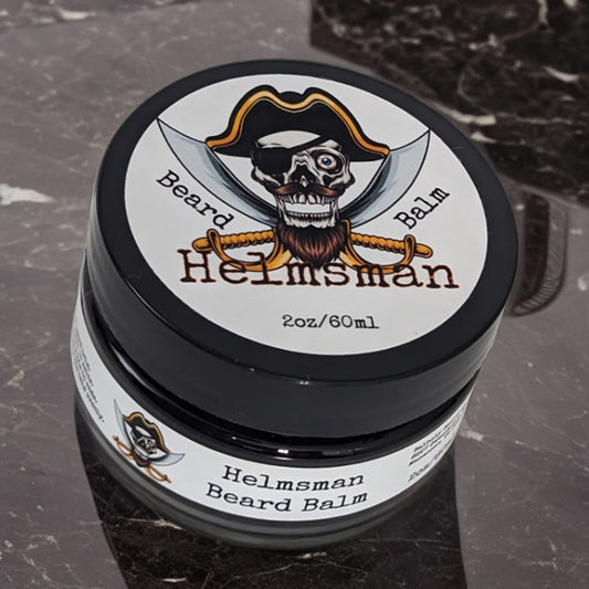 Helmsman beard balm tin on a black marble counter